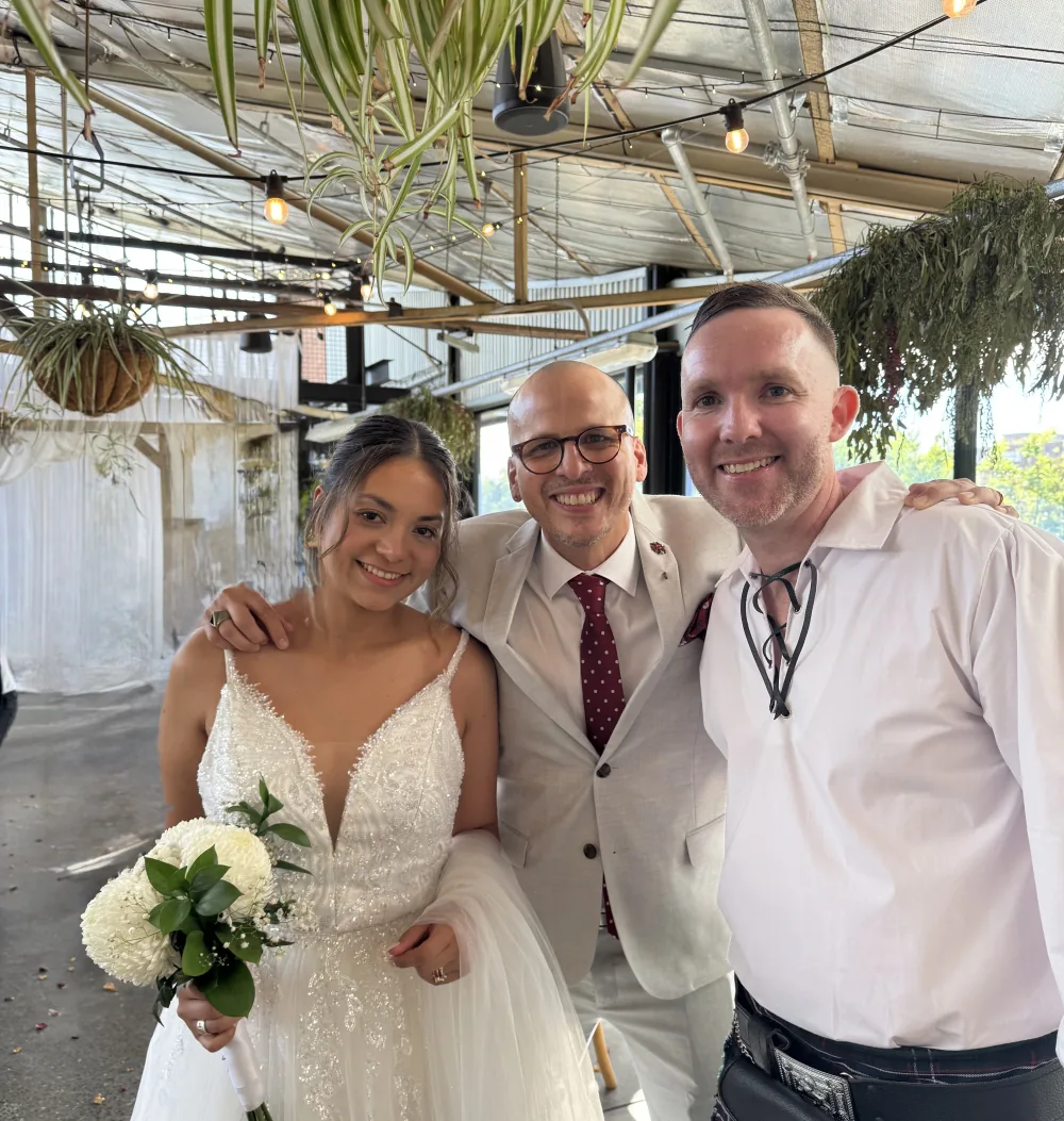 A bride and groom either side of Andrés after their intimate Adelaide wedding