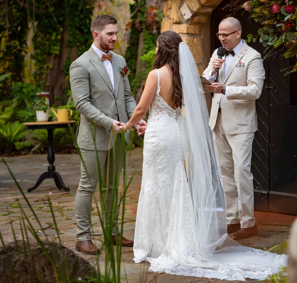 A couple exchanging vows in a garden ceremony led by Andrés