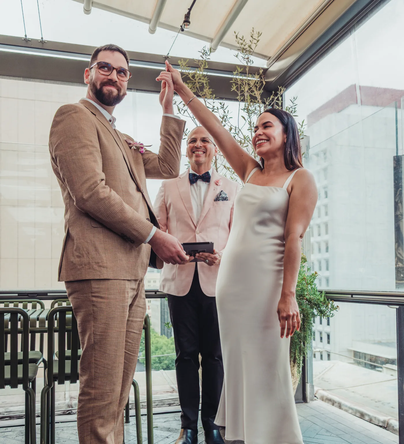 A couple celebrating with raised hands as Andrés marries them in Adelaide